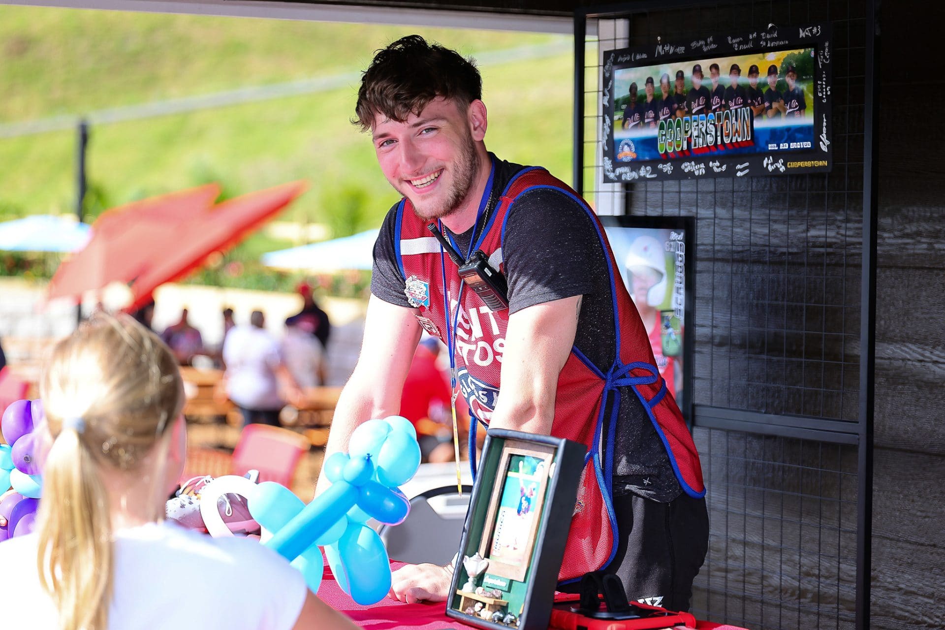 Crew member smiling at the Glossy Finish photo counter while helping a young customer