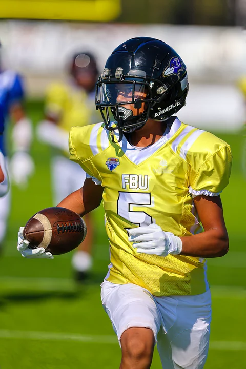 Ball carrier in yellow running with the ball