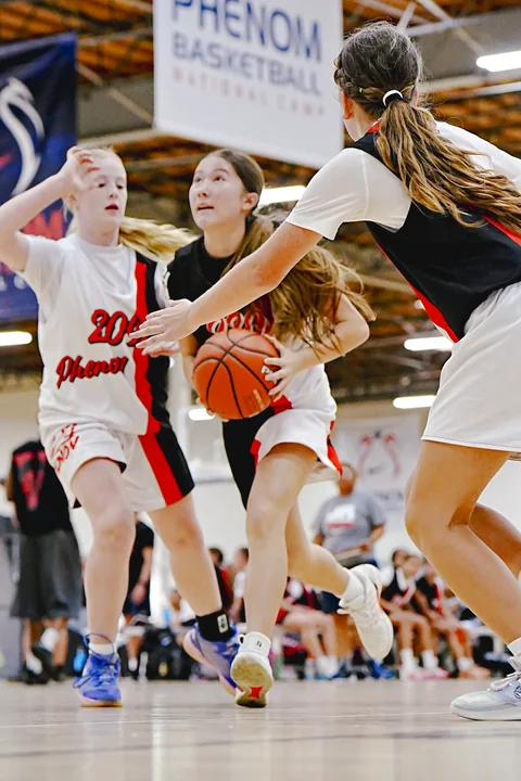 Guard driving between two defenders