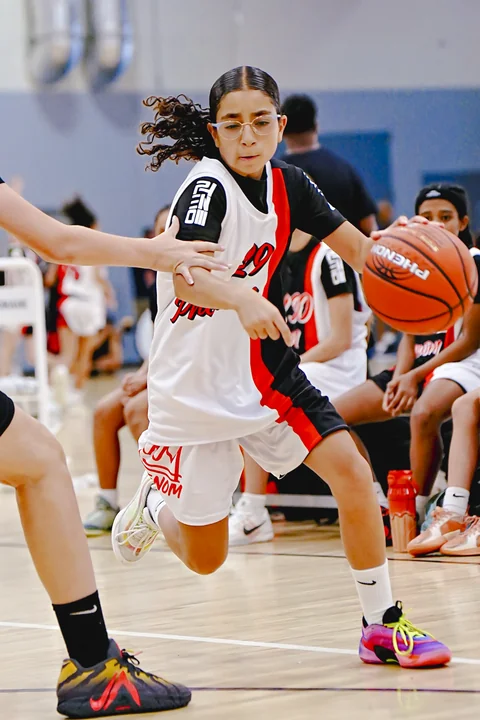 Guard in white driving past a reaching defender