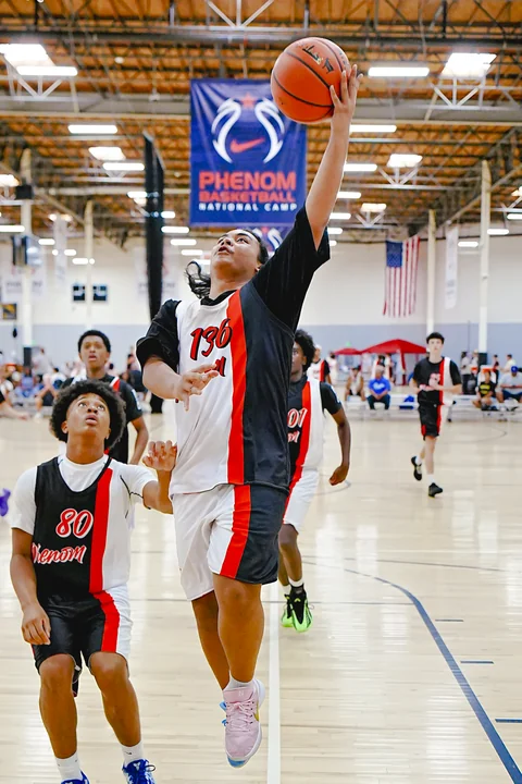 Player in white reaching high for a layup