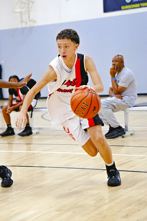 Guard in white driving to the basket