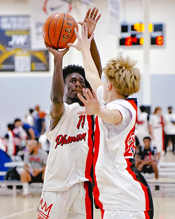 Player in white shooting over a defender