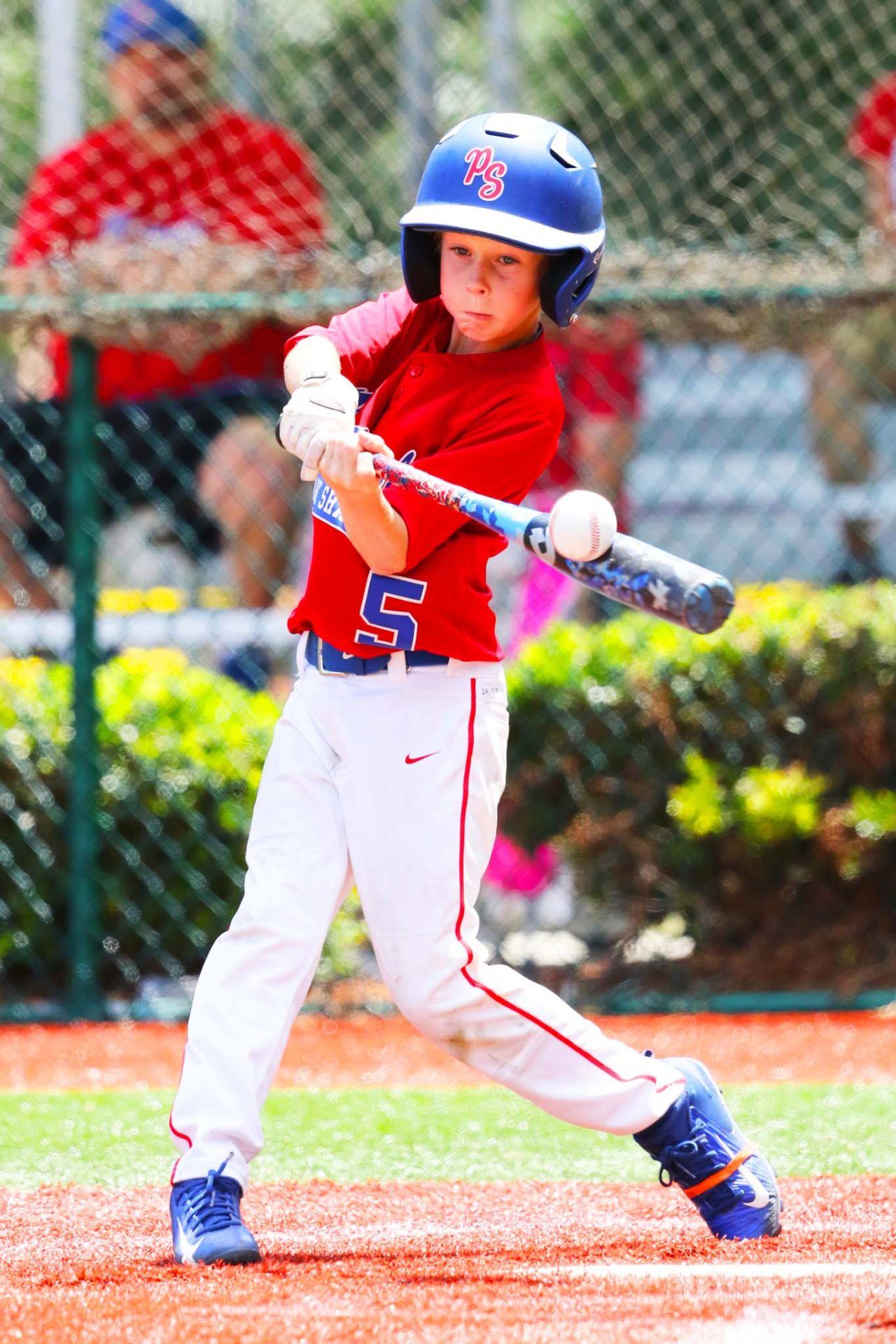 Batter in red swinging at a pitch