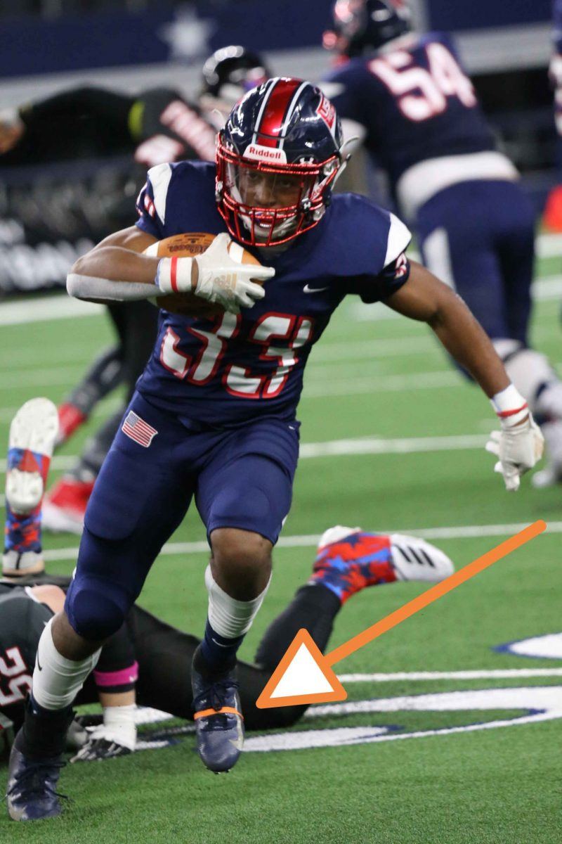 Football player running with the ball, an arrow pointing to the orange band on his cleat